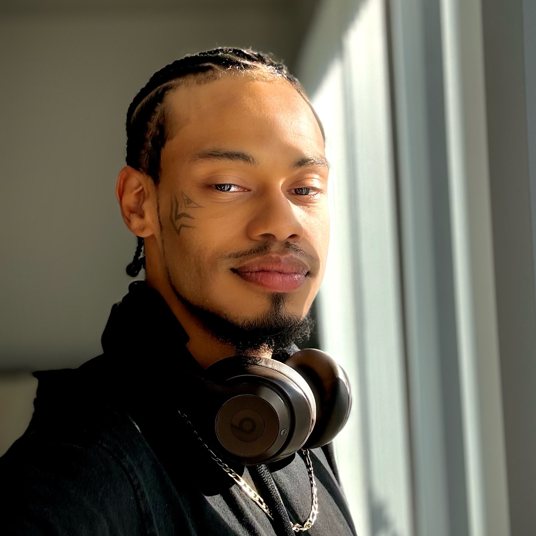 Soular Amor Rey in window light, wearing headphones
